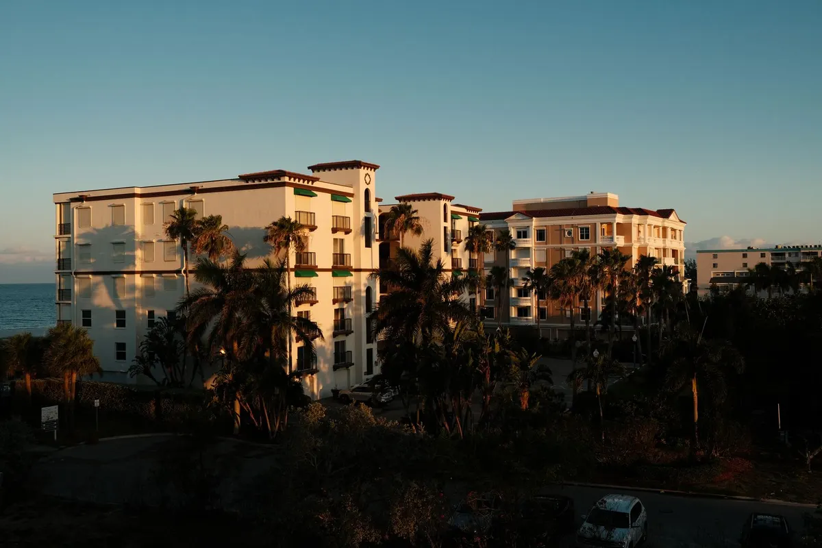 Low-rise buildings among palm trees in St. Petersburg at sunset